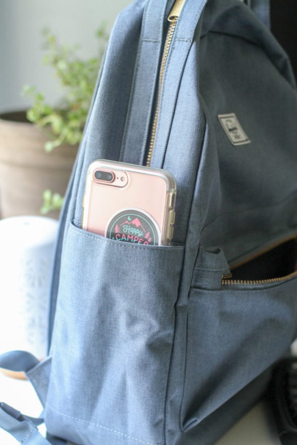A pink phone in a blue backpack pocket.
