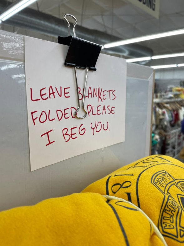 thrift store sign that says, "leave blankets folded I beg you".
