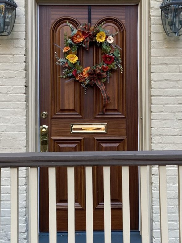 brown door with a fall wreath.