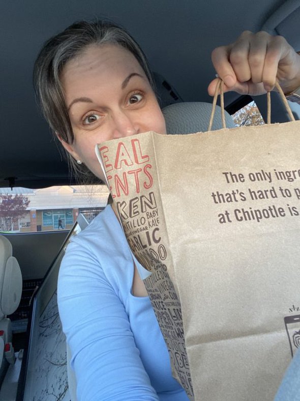 Kristen holding a chipotle bag.