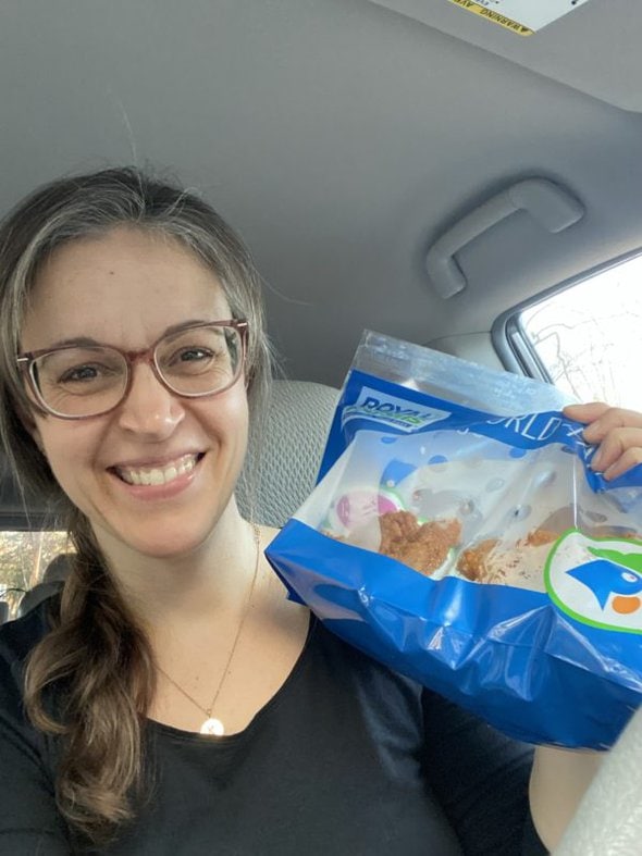 Kristen holding a bag of fried chicken.